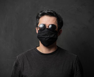 Siyah maskeli, esmer, yorgun bir adam.