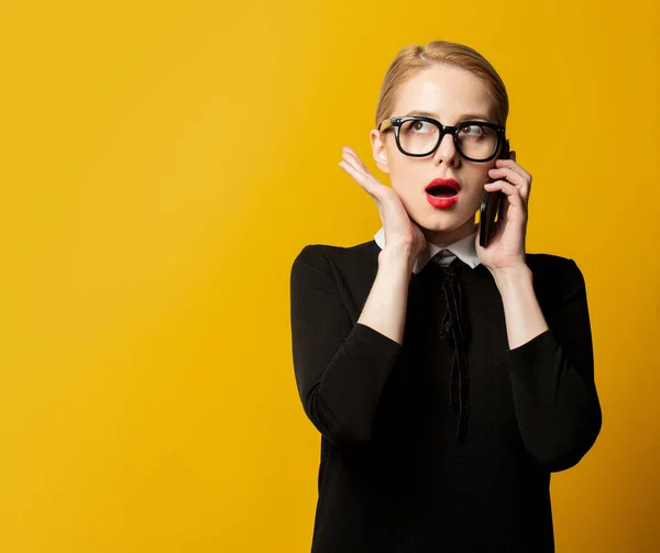 Verrast Vrouw Zwart Formele Kleding Met Mobiele Telefoon Gele Achtergrond — Stockfoto