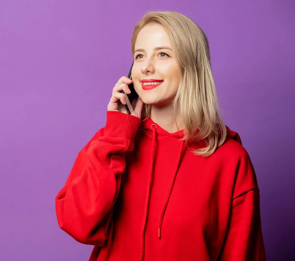 Glimlachende Blonde Vrouw Rode Sweater Met Behulp Van Mobiele Telefoon — Stockfoto