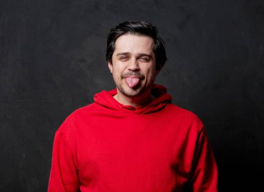 Siyah arka planda kırmızı kazaklı beyaz adam.