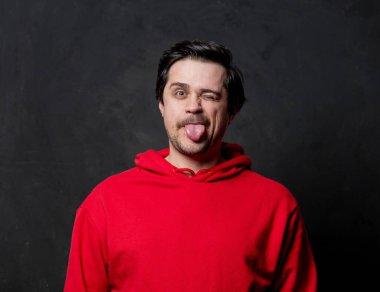 Siyah arka planda kırmızı kazaklı beyaz adam.