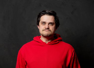 Siyah arka planda kırmızı kazaklı beyaz adam.