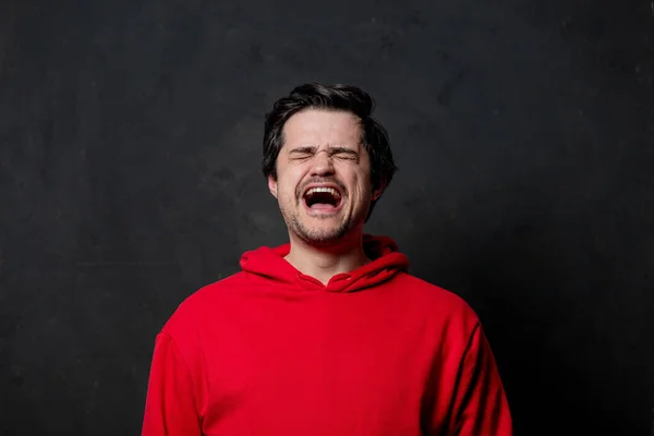 Weißer Trauriger Typ Rotem Sweatshirt Auf Dunklem Hintergrund — Stockfoto
