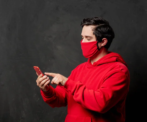 Tipo Sudadera Roja Mascarilla Usando Teléfono Móvil Sobre Fondo Oscuro —  Fotos de Stock