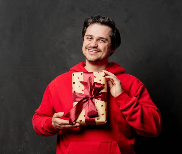 Chico Blanco Sudadera Roja Sostiene Caja Regalo Sobre Fondo Oscuro —  Fotos de Stock