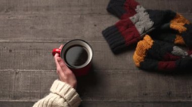 Kadın eli, bir fincan kahve ve eşarp ile ahşap masada. 