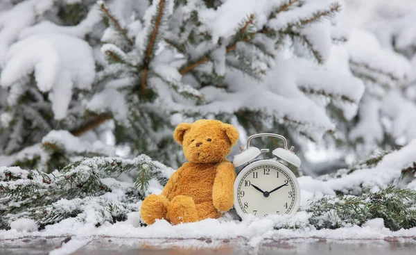 テディベアおもちゃと目覚まし時計オン木製テーブルで雪 — ストック写真