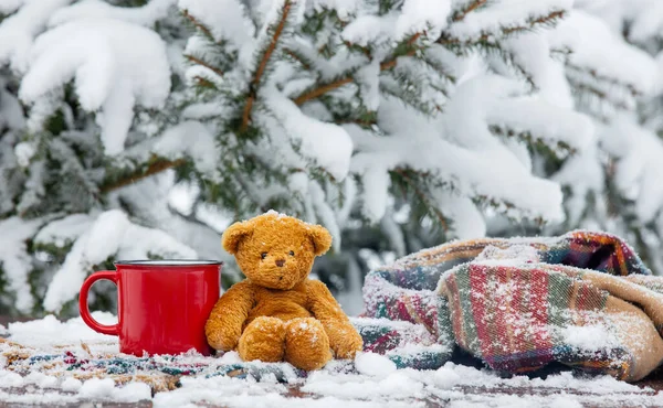 コーヒーとスカーフの赤いカップでテディベアと木製のテーブルの上に吹雪 — ストック写真