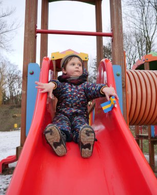 Küçük çocuk kışın parkta tek başına oynuyor.. 