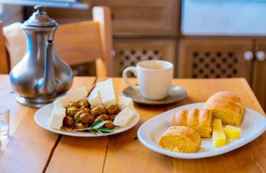 Geleneksel Girit kahvaltısı, ekmek, peynir ve kahve bir mutfaktaki ahşap masada. Girit, Yunanistan