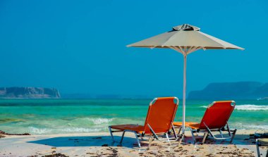 Yaz mevsimi, Temmuz 'da Yunanistan' ın Balos gölündeki güneşlik ve şemsiye manzarası