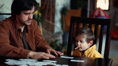 Babam küçük bir çocuğa evde ABA terapi programı altındaki kartlardan bir şeyler öğretiyor. 