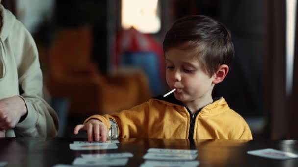 在美国律师协会的治疗计划下 小男孩在家里的饭桌上从卡片中学习单词 — 图库视频影像
