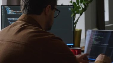 erkek programcı evdeki bir bilgisayara kod yazar