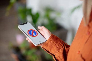 Wroclaw, Polonya - 20 Mart 2021: Evdeki ekranda engellenmiş Facebook logosu olan iPhone 12 'yi tutan kadın