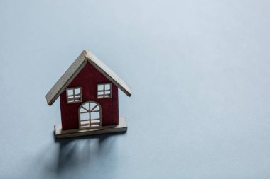 Gri arka planda gölgesi olan tahta oyuncak ev. Deprem konsepti 