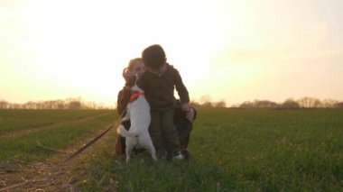 Anne ve oğul gün batımında kırsal bir yolda otururken kucaklaşıyorlar.