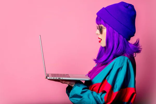 Ler Eşofmanlı Şık Bir Kız Pembe Arka Planda Dizüstü Bilgisayar — Stok fotoğraf