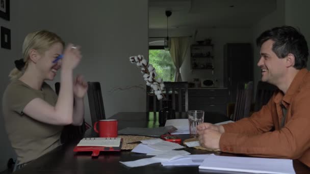 夫と妻は家のテーブルに座りながら請求書を処理します — ストック動画