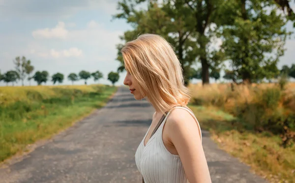金发碧眼的女人走在乡间小路上 — 图库照片