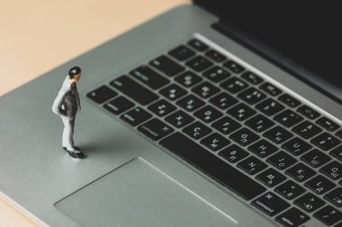 Dizüstü bilgisayardaki bir iş adamının minyatür figürü 