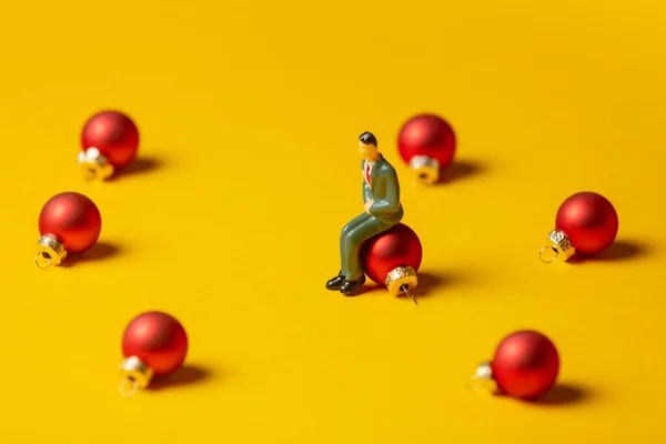 Figura Miniatura Dell Uomo Siede Bauble Natale Sfondo Giallo — Foto Stock