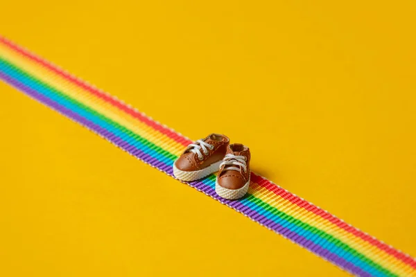Sapatos Pequenos Faixa Arco Íris Lgbt Fundo Amarelo — Fotografia de Stock