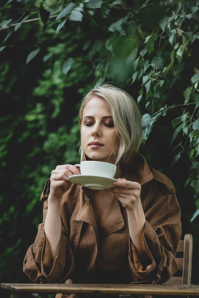 Beautiful Woman Coat Cup Coffee Wooden Table Garden Trees Background — Stock Photo, Image