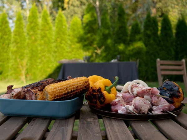 Bir masada ızgara mısır ve domuz eti. 