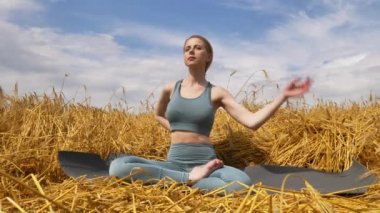 Kız buğday tarlasında yoga yapıyor.