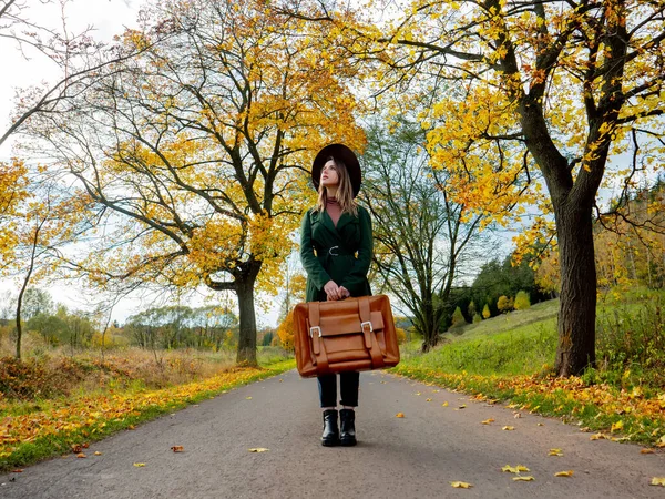 Frau Grünem Mantel Mit Koffer Auf Landstraße Zur Herbstzeit — Stockfoto