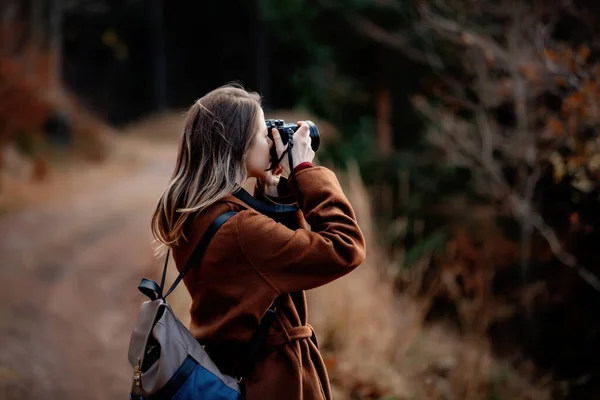 カメラを持った女性が山の森で写真を撮る — ストック写真