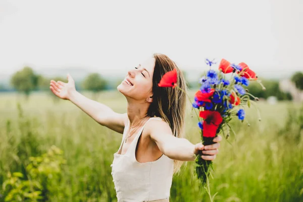 若いです女性のドレスでフィールドの近くに滞在花束のCentaureaとPoppy花 — ストック写真