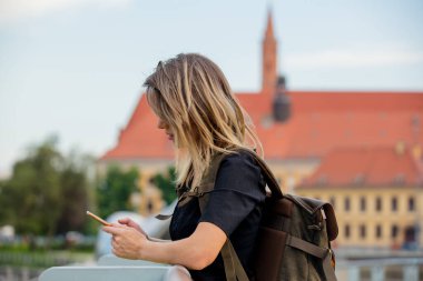 Akıllı telefonu ve sırt çantası olan genç bir kız.