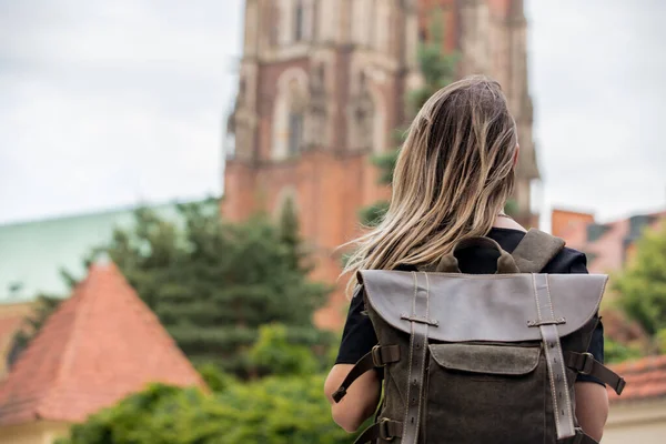 在欧洲的旧教堂的背景下 一个背着背包的小女孩 — 图库照片