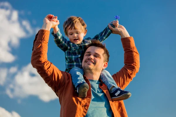 Kleiner Junge Sitzt Auf Den Schultern Seines Vaters Auf Blauem — Stockfoto