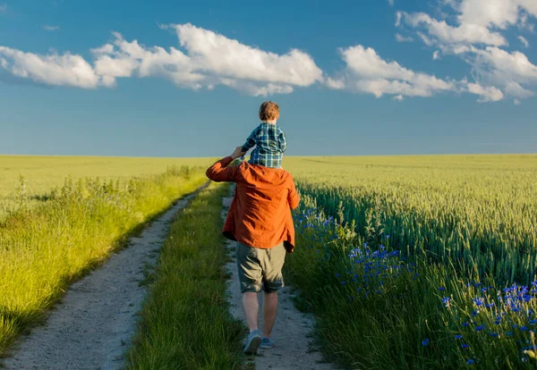 Kleine Jongen Zit Schouders Van Zijn Vader Een Landelijke Weg — Stockfoto