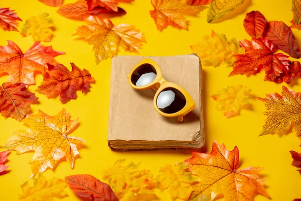 Libro Romantico Occhiali Sole Con Foglie Autunnali Sfondo Giallo Vista — Foto Stock