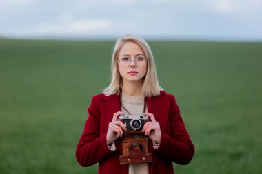 Buğday tarlasında gözlüklü sarışın kadın.