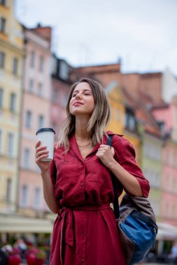 genç kadın sokakta yürürken yolda kahve içiyor