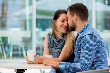 genç çift bir kafede bir masada oturan ve kahve içme