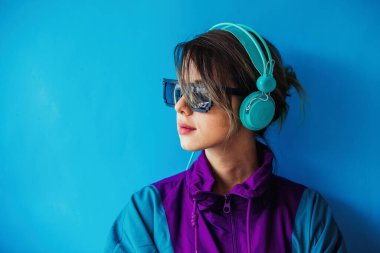 90 'ların tarzı ceketli ve kulaklıklı genç bir kadın.