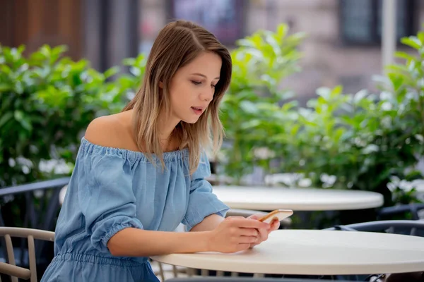 Mladá Dívka Mobilním Telefonem Sedí Stolu Kavárně — Stock fotografie