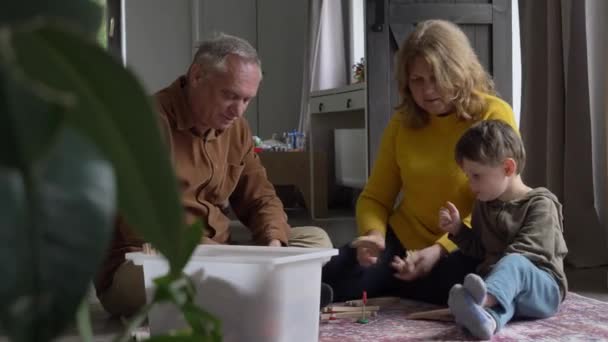 Mor Och Farföräldrar Leker Järnväg Med Sitt Barnbarn Hemma Video — Stockvideo