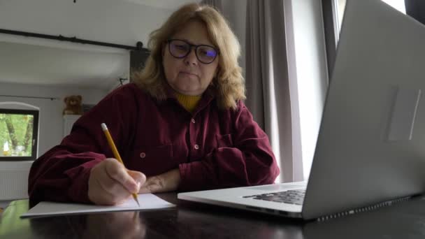 Donna Anziana Siede Computer Scrive Qualcosa Sulla Carta — Video Stock