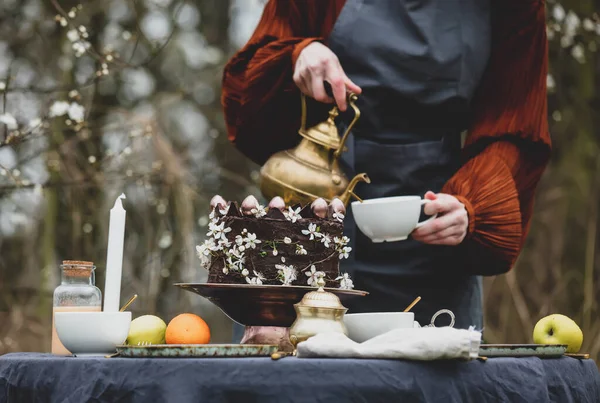 Vrouw Schenkt Thee Een Kopje Tuin Buurt Van Kersentuin — Stockfoto