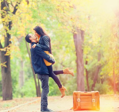 Картина, постер, плакат, фотообои "пара с чемоданом, целующимся на аллее в парке
", артикул 51921535