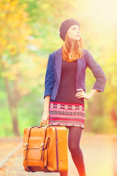 Rothaarige Mädchen mit Koffer im Herbst im Freien. — Stockfoto