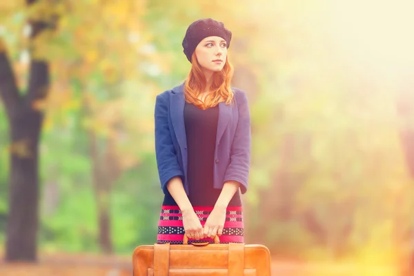 Fille rousse avec valise à l'automne en plein air . — Photo