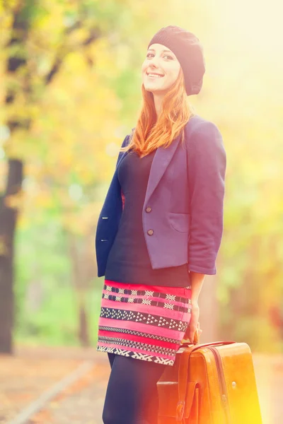 Fille rousse avec valise à l'automne en plein air . — Photo